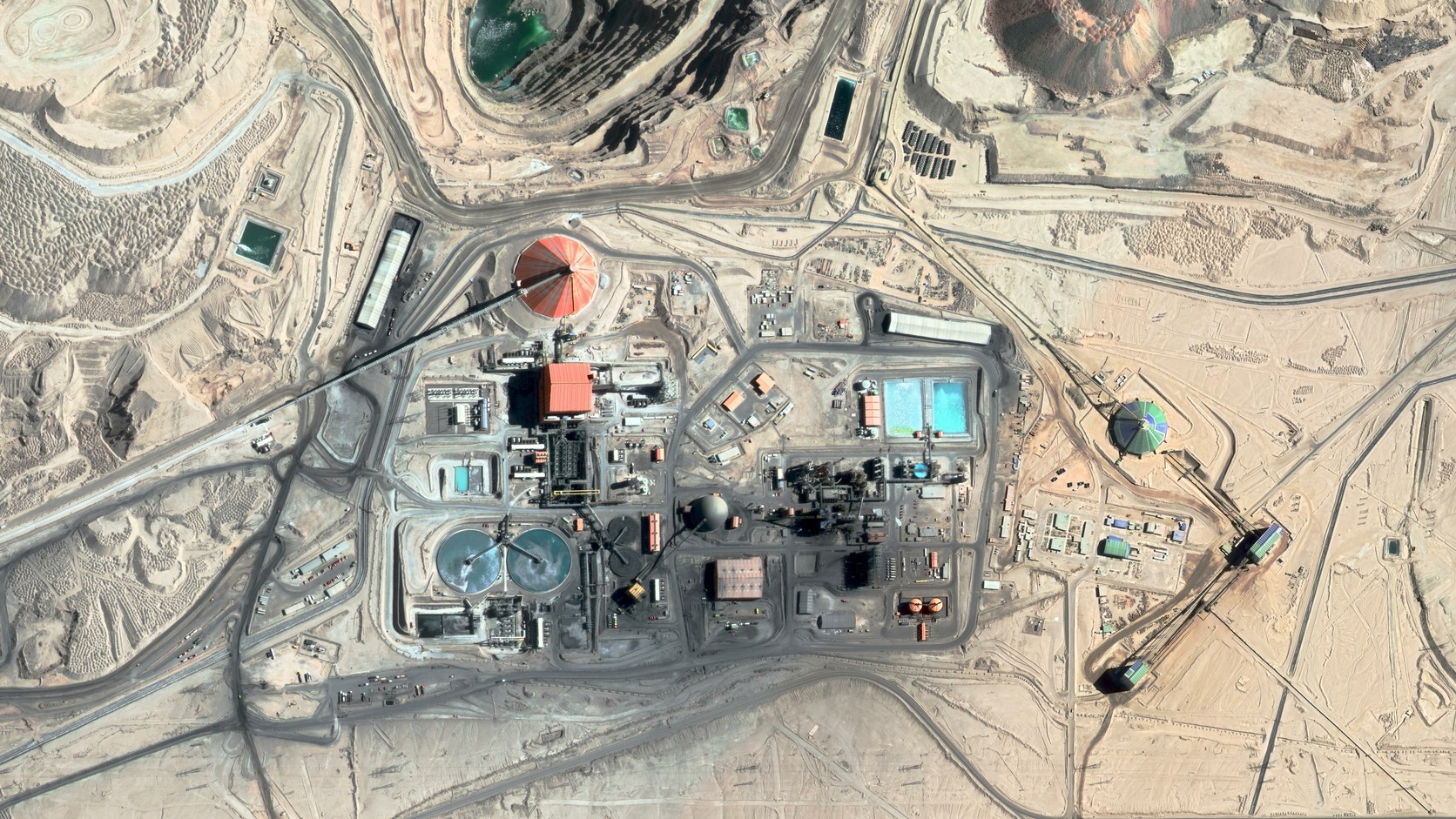 Aerial view of mine processing infrastructure and haul roads in an arid region